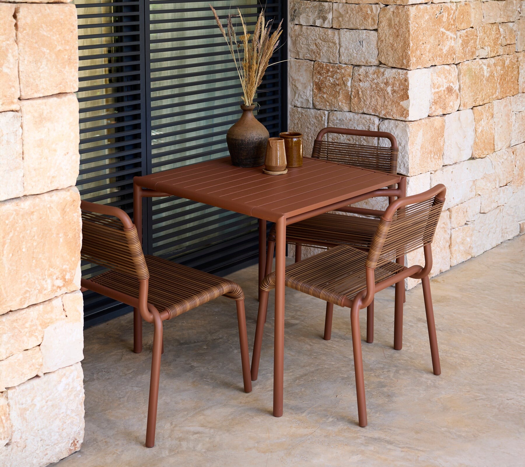 Cane-line Al Dente chairs at a terracotta cafe table on a terrace