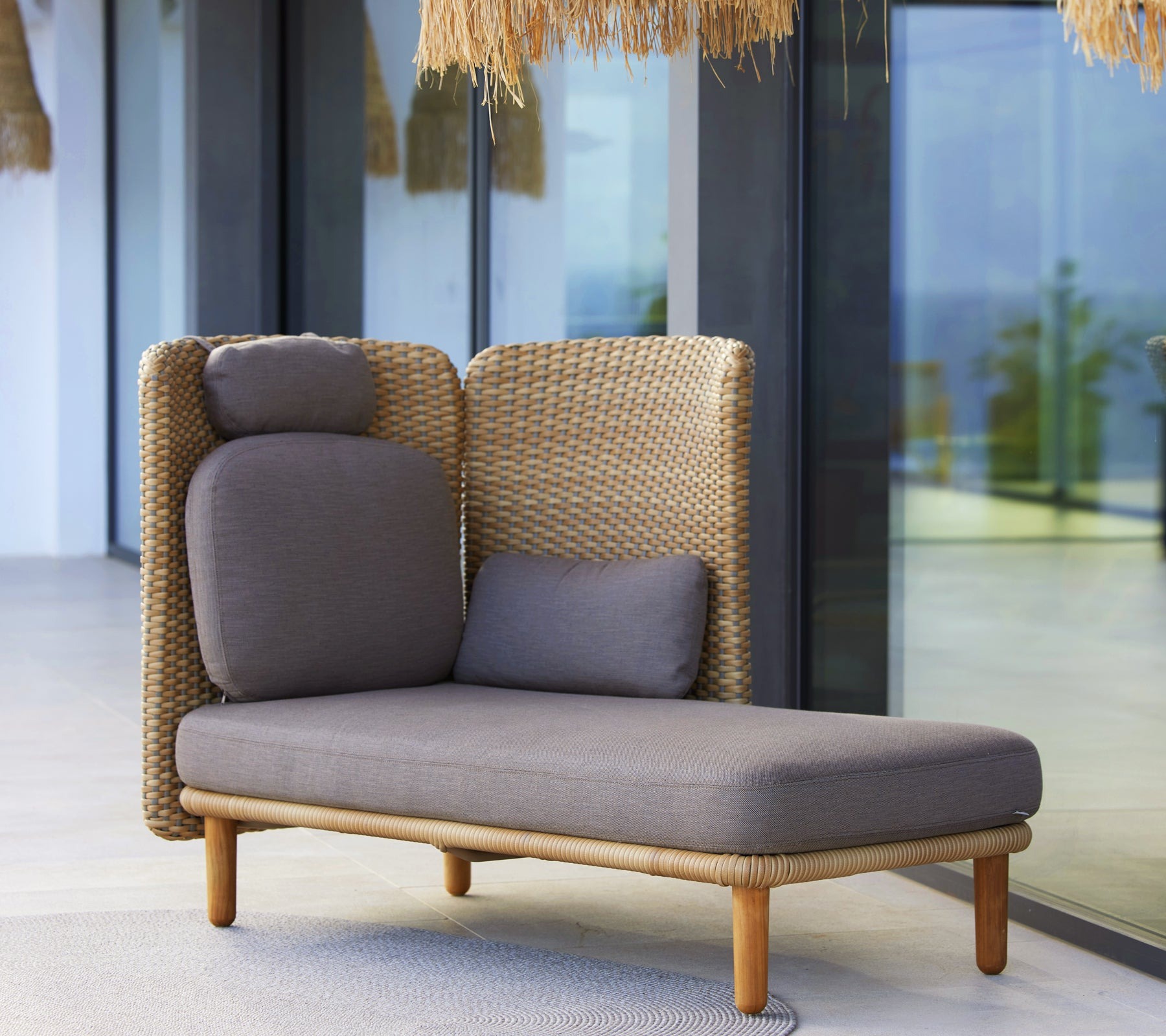 Cane-line Arch outdoor lounge sofa and chair in natural Soft Rope on a terrace by the water