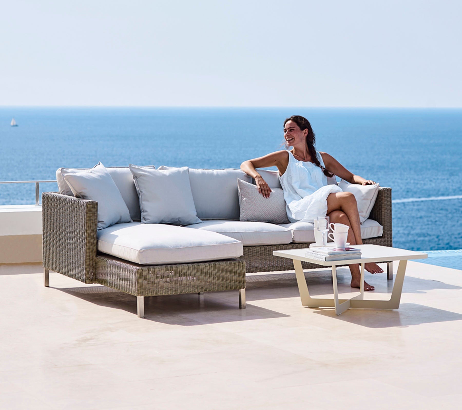 Cane-line Connect modular outdoor sofa in light weave on a terrace overlooking the sea