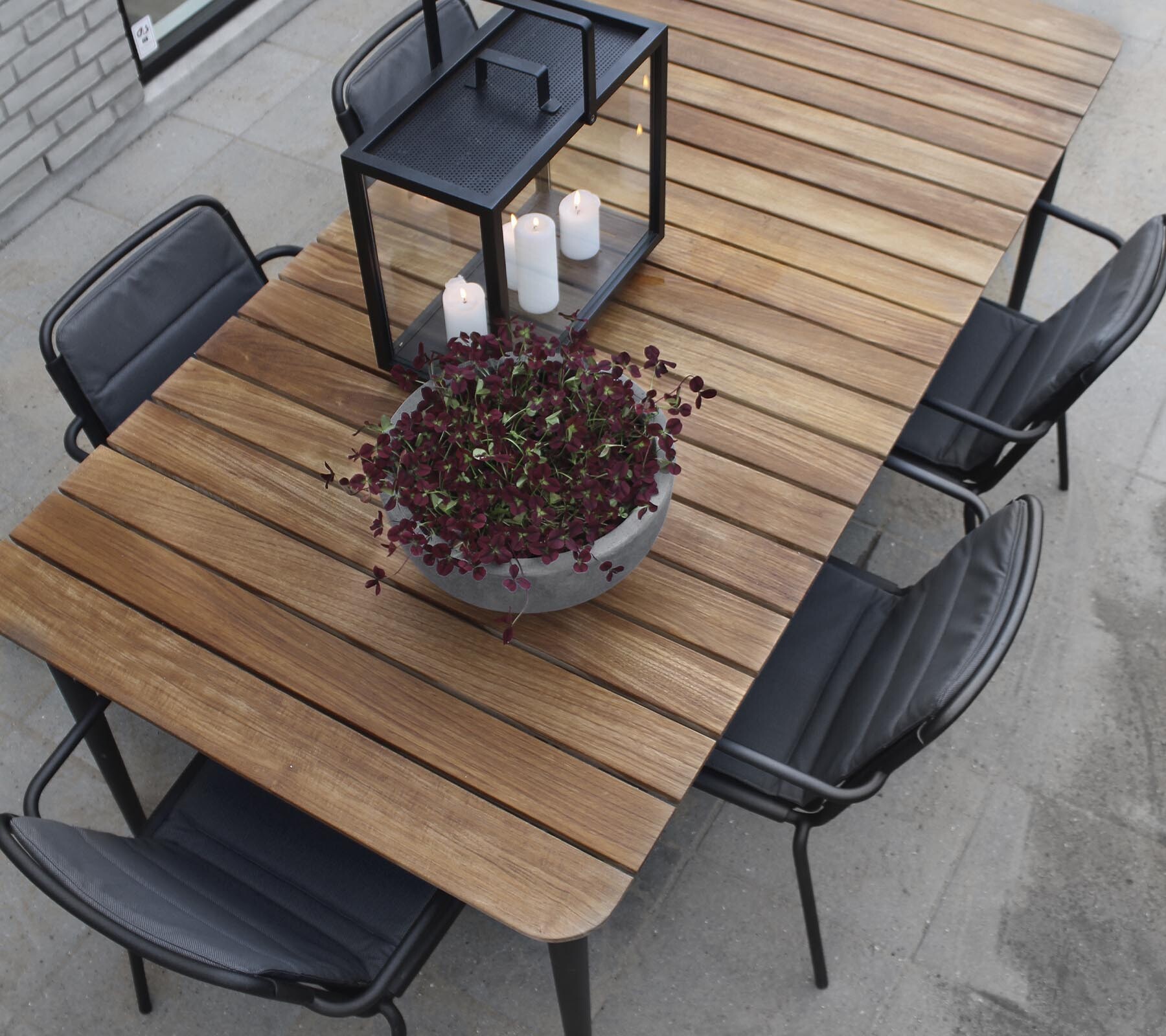 Cane-line Core teak dining table with dark grey chairs, viewed from above
