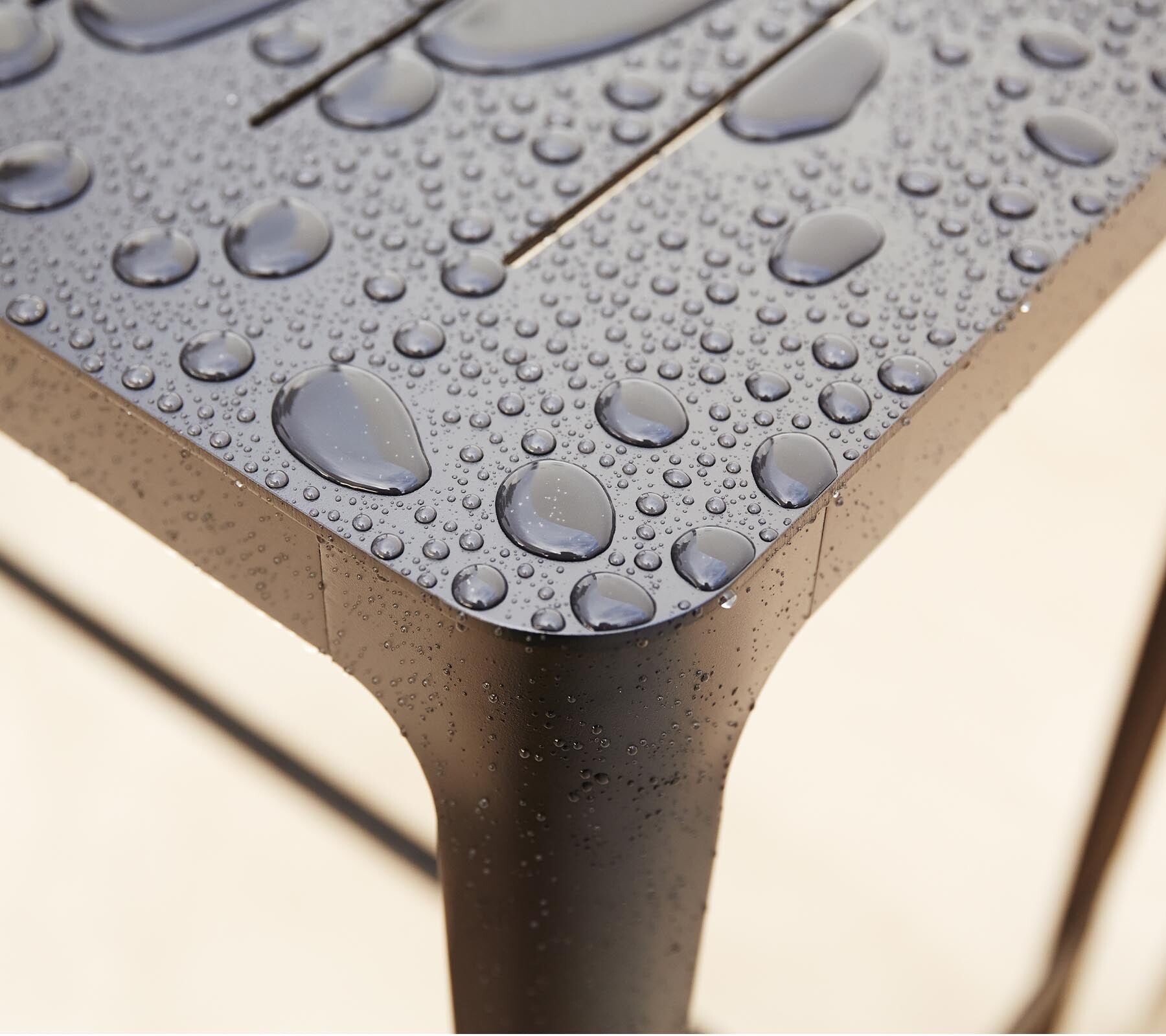 Cane-line Cut bar table and stools on a wood terrace