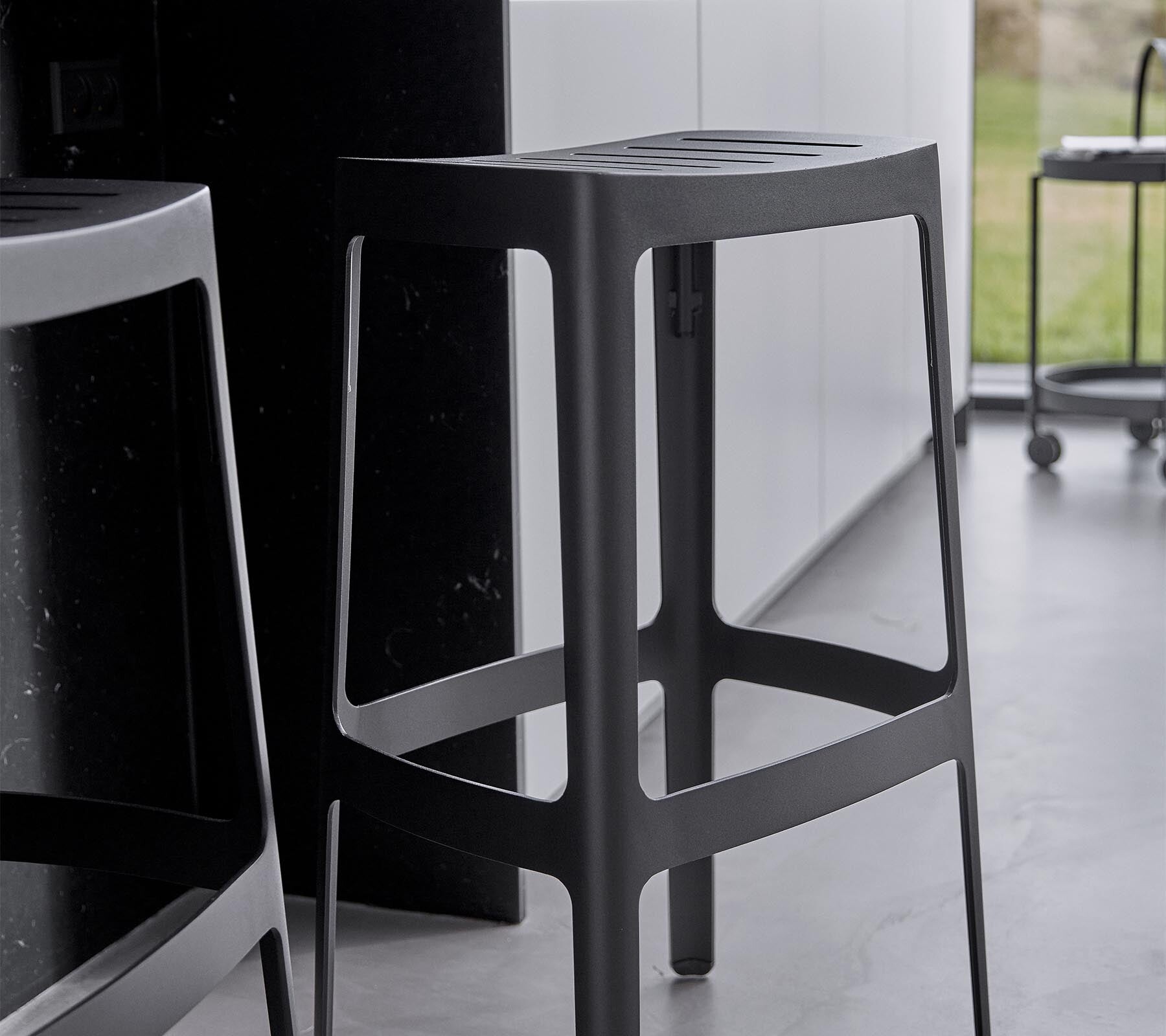 Cane-line Cut outdoor bar stools in a garden