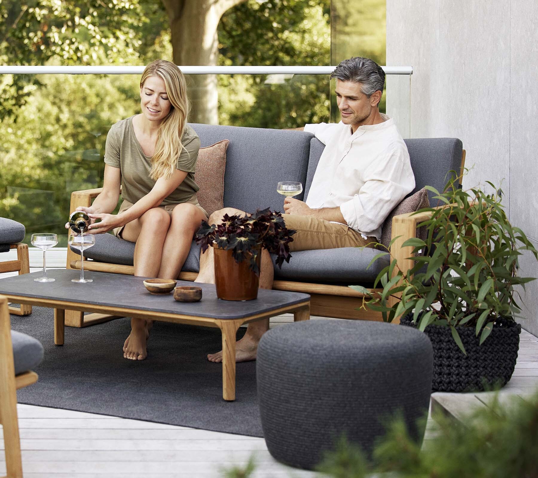 Cane-line Endless Soft sofa and coffee table with two people on a terrace