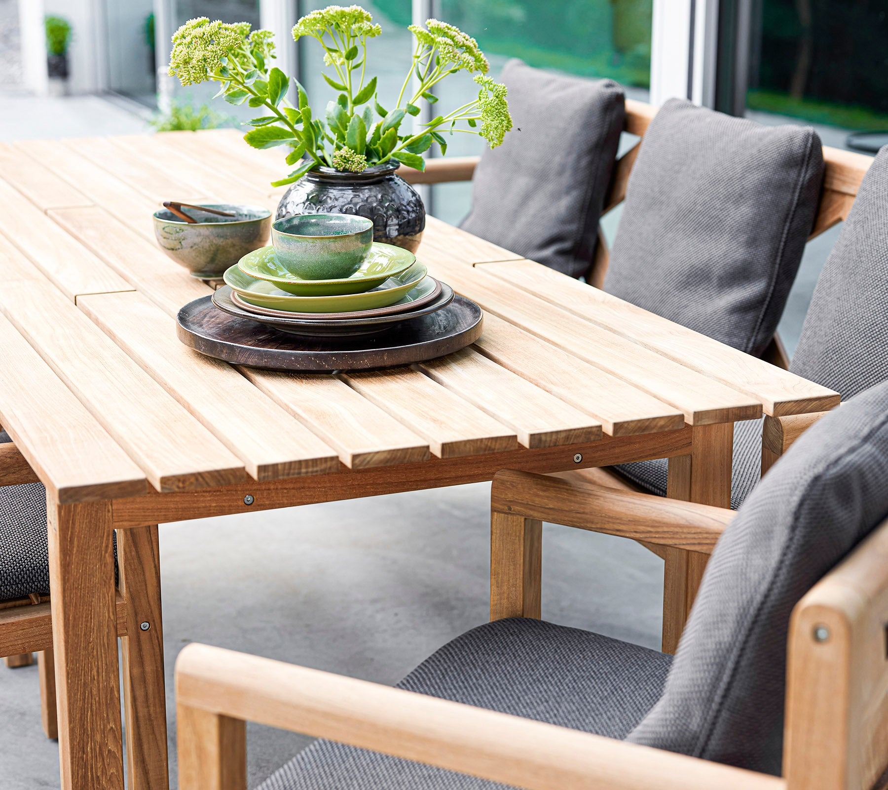 Cane-line Grace outdoor teak dining collection set for a meal on a terrace