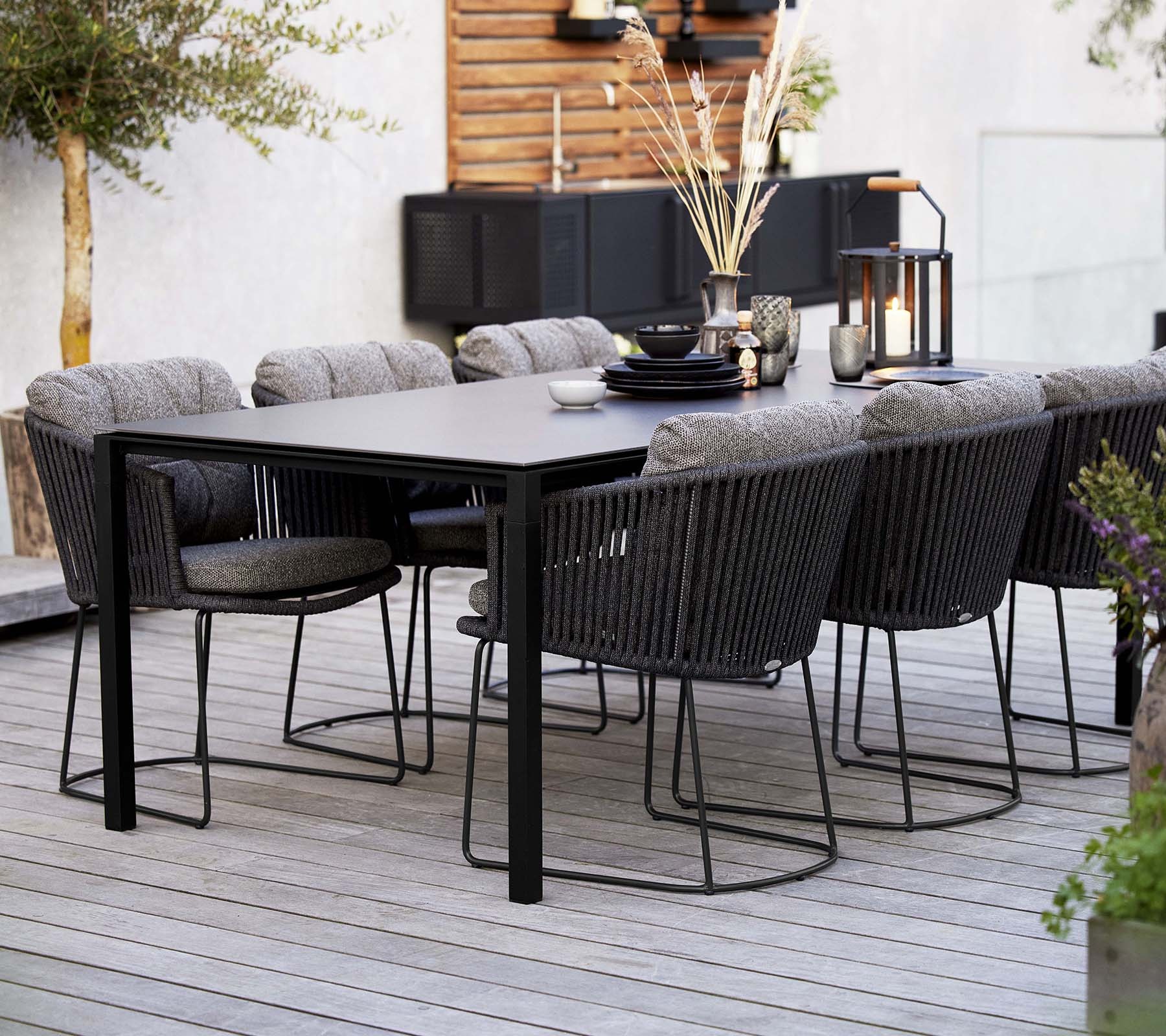 Cane-line Moments outdoor dining table and grey Soft Rope chairs styled on a terrace