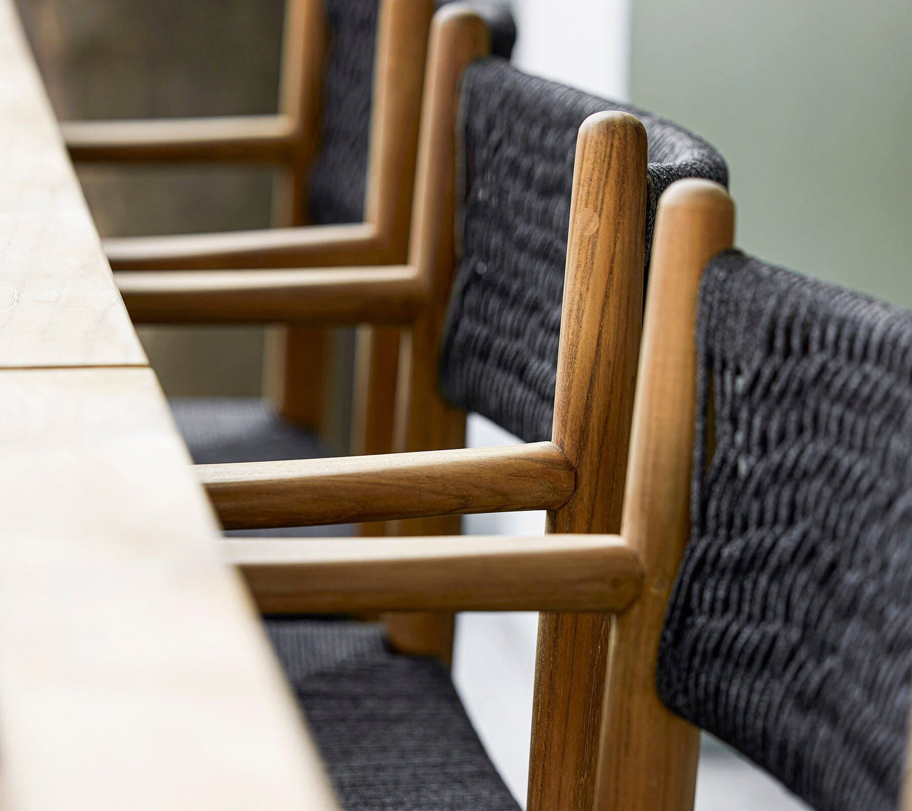 Cane-line Royal teak armchairs along a dining table, detail