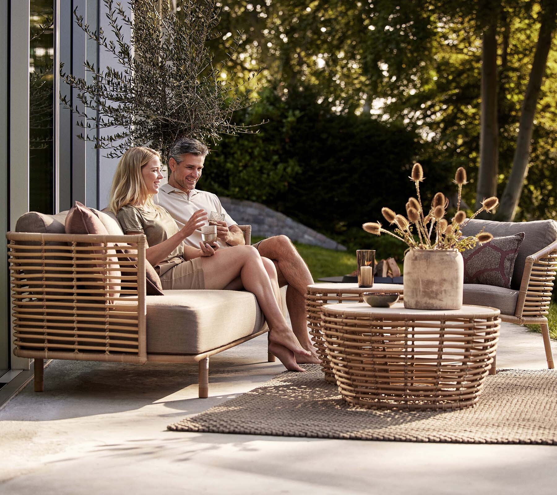 Cane-line Sense lounge set with people on a garden terrace