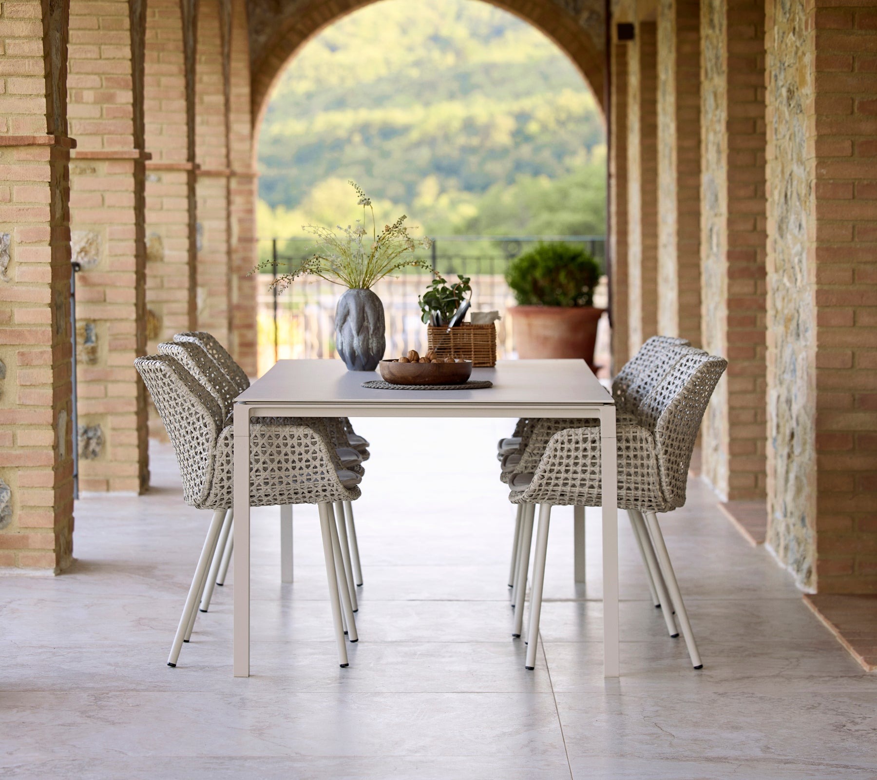 Cane-line Vibe outdoor dining chairs at a table under a loggia