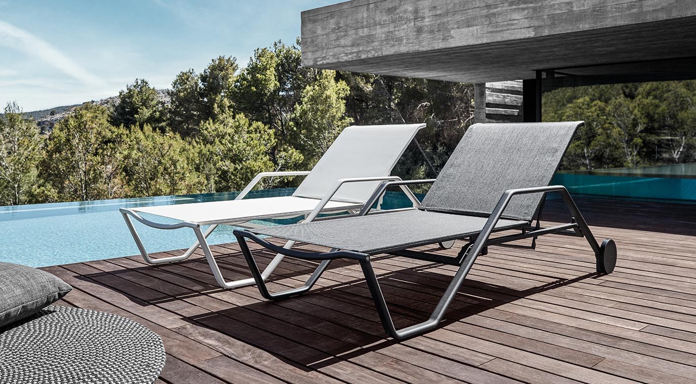 Gloster 180 stacking loungers on a timber deck beside a pool